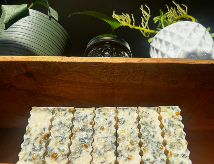 Wooden Shelf with bars of soap with decorative plants above.