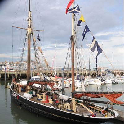 Boats in Lowestoft Harbour with flags and pedants