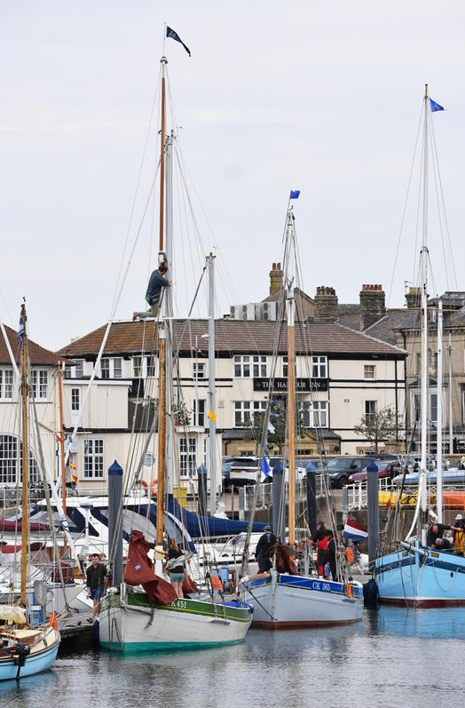 Boats are docked in a harbor with buildings in the background
