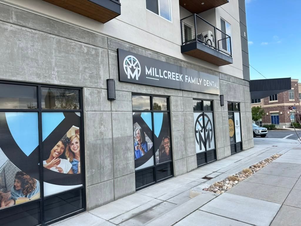 Mill Creek Signworks storefront on a snowy sidewalk, with large window graphics and a concrete facade