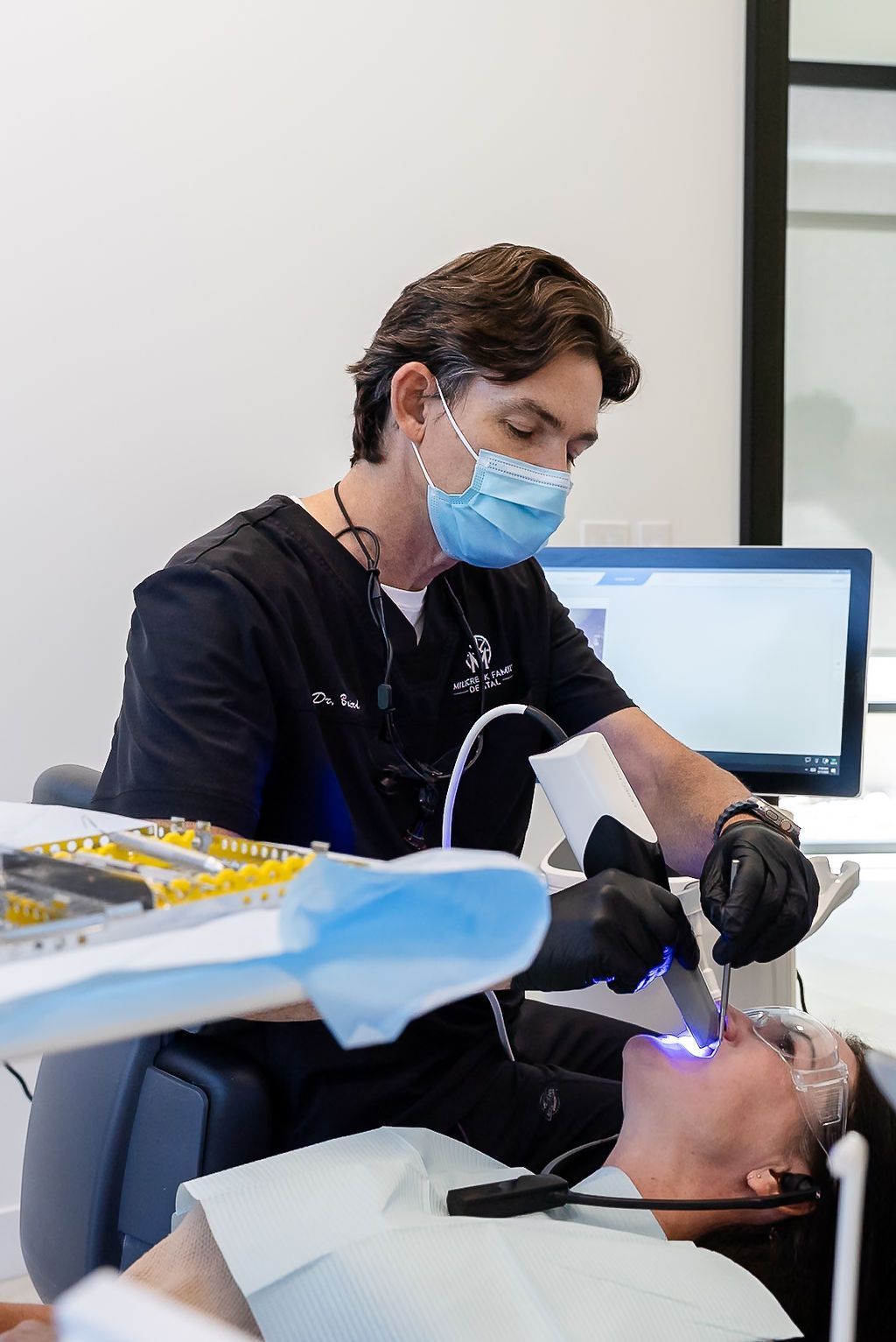 Dentist in mask and gloves working on a patient in a dental chair