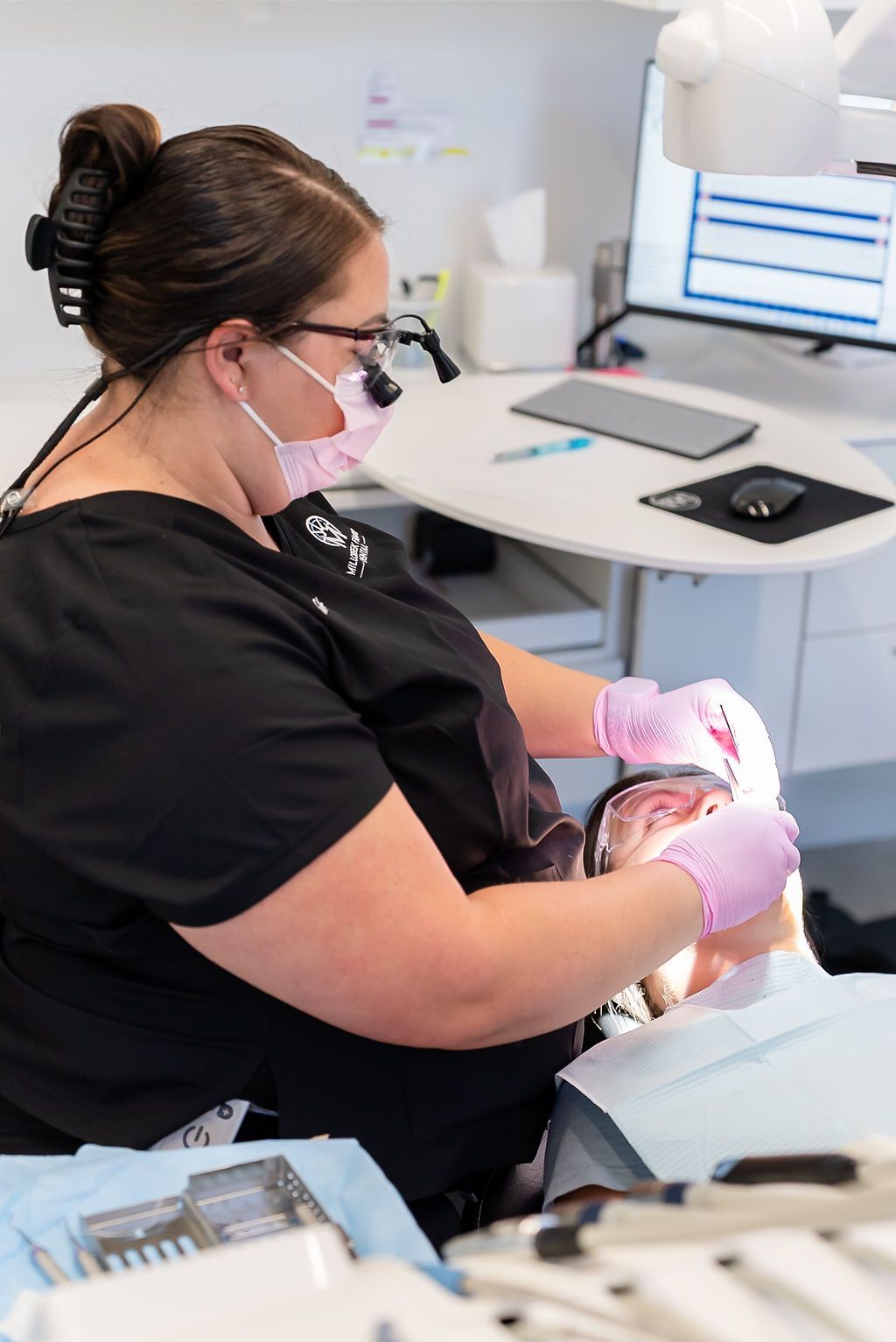 Dental hygienist performing a professional teeth cleaning for a patient during a routine dental visit