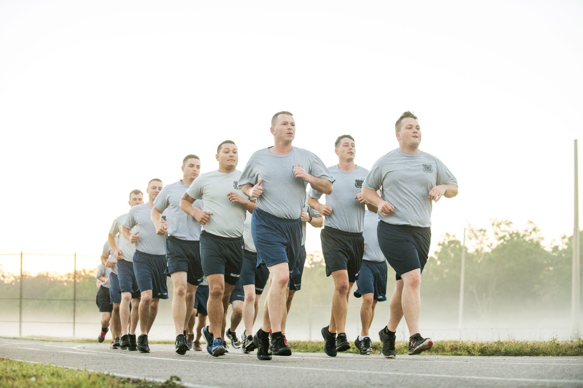 A group of men are running down a road.