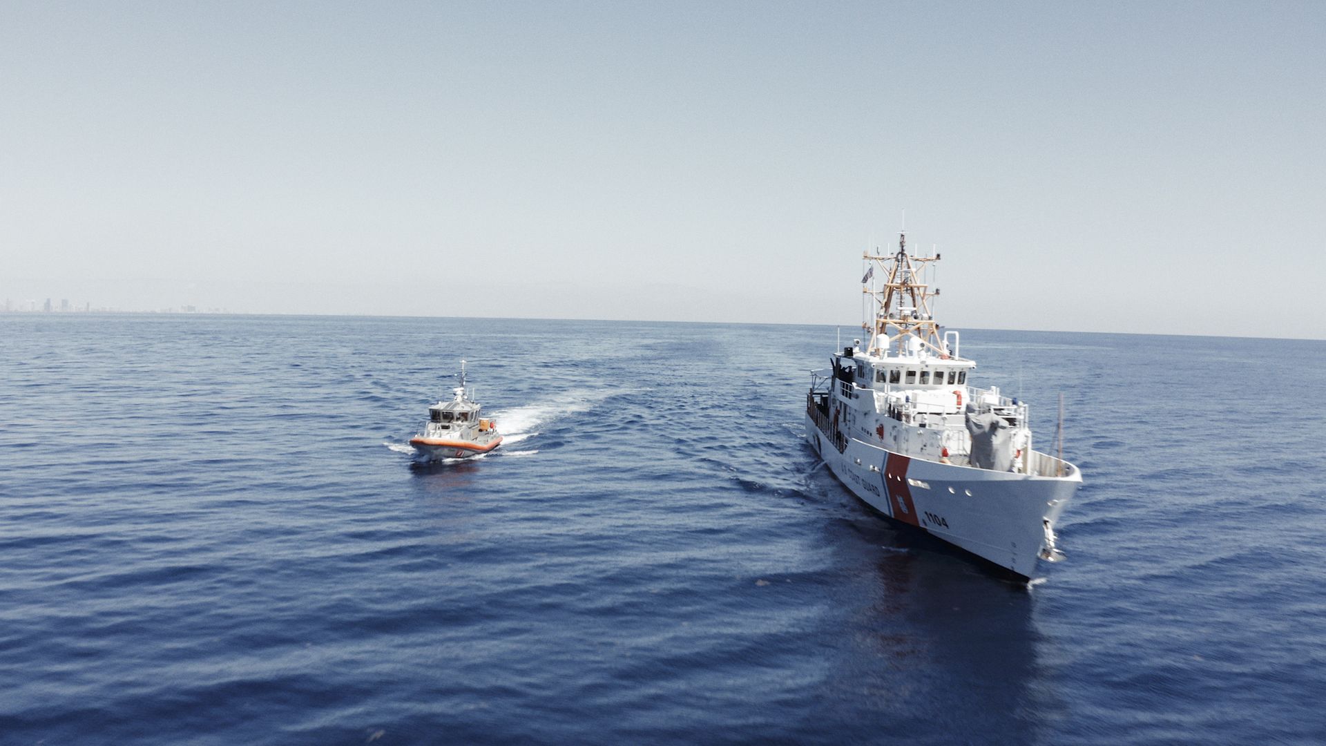 Two boats are floating on top of a large body of water.