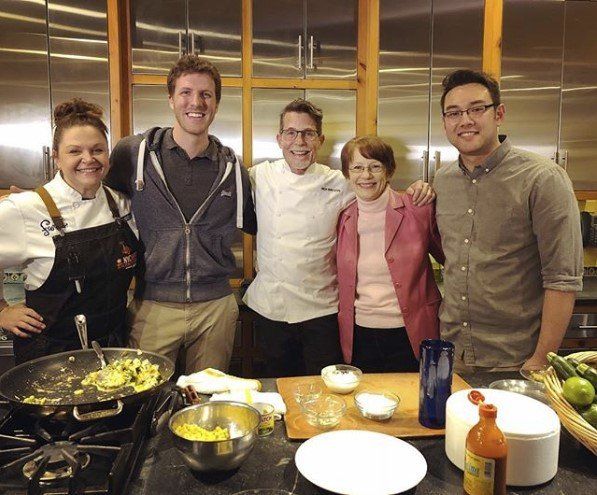 A group of people posing for a picture in a kitchen