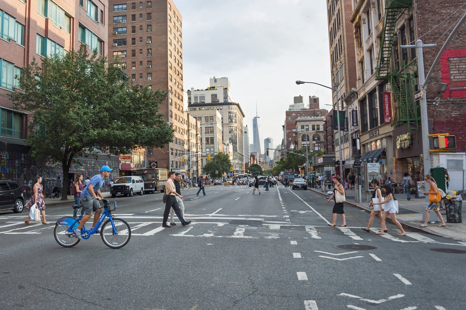 A man is riding a bike down a busy city street.
