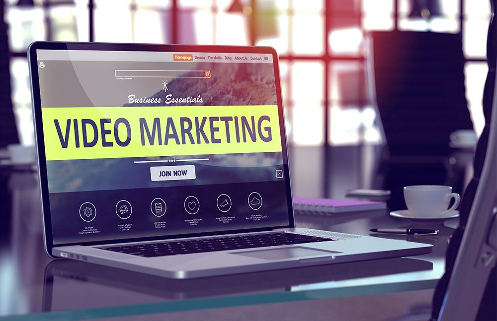 A laptop computer is open to a video marketing website.