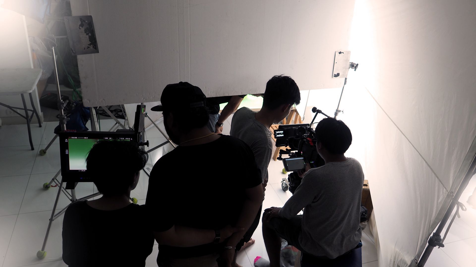 A group of people are standing around a table in a room.