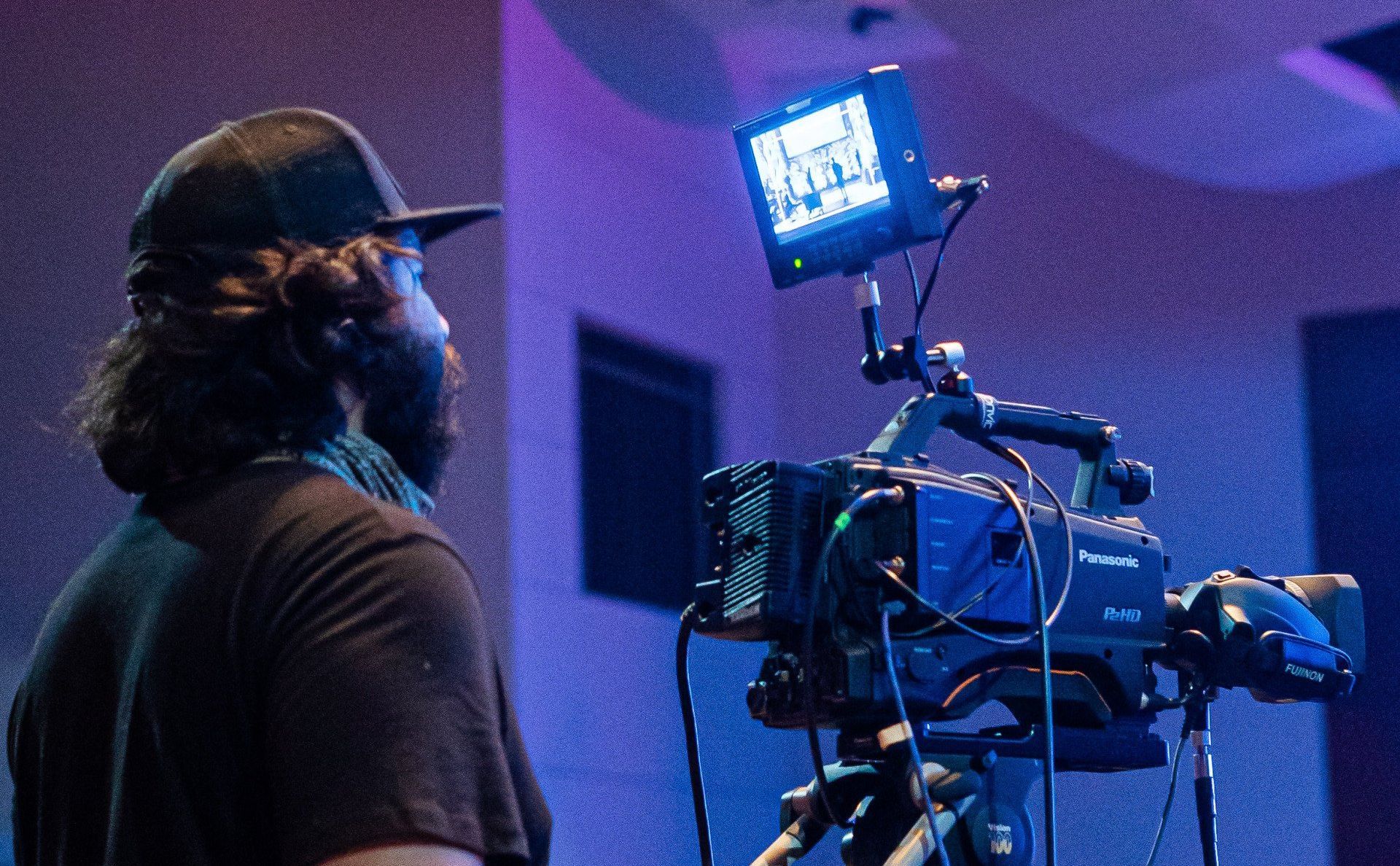 A man is standing in front of a video camera.