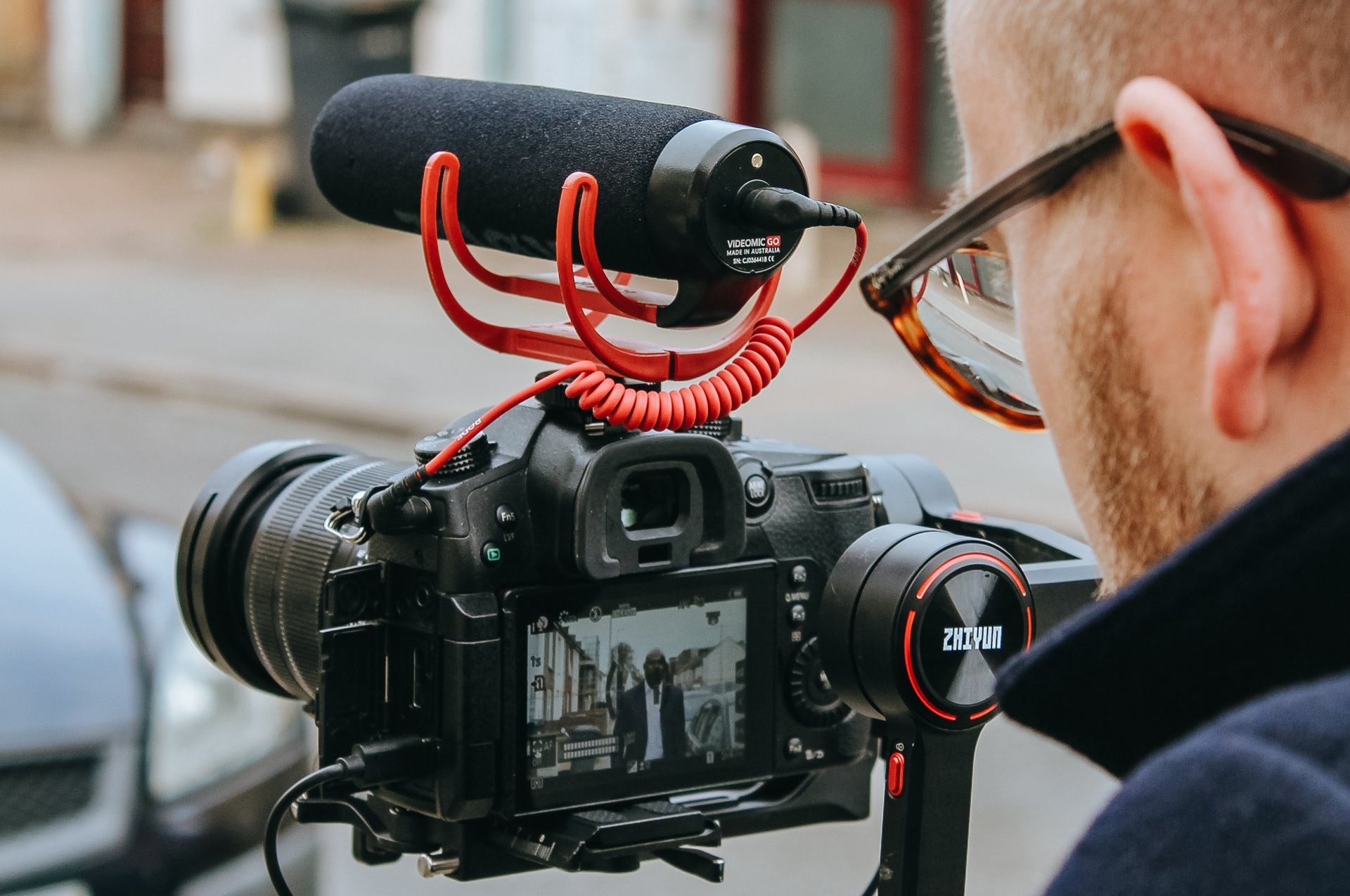 A man is holding a camera with a microphone attached to it.
