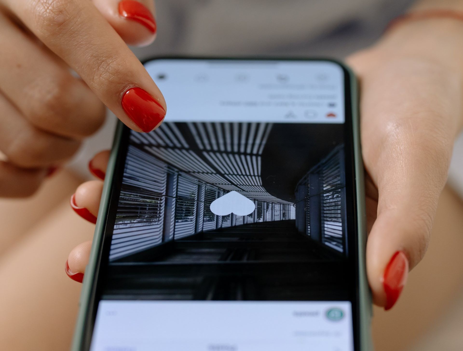 A woman with red nails is holding a cell phone