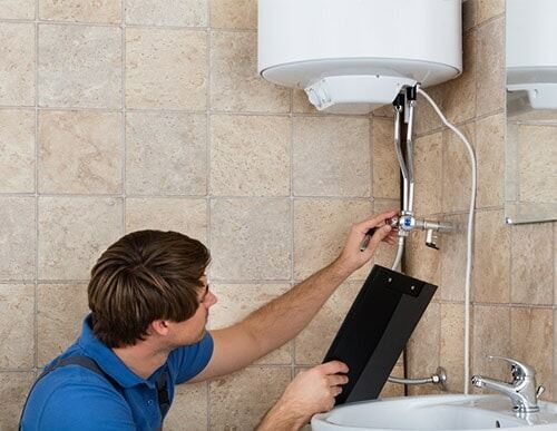 Plumber Checking Electric Boiler — Hot water system in Armidale, NSW