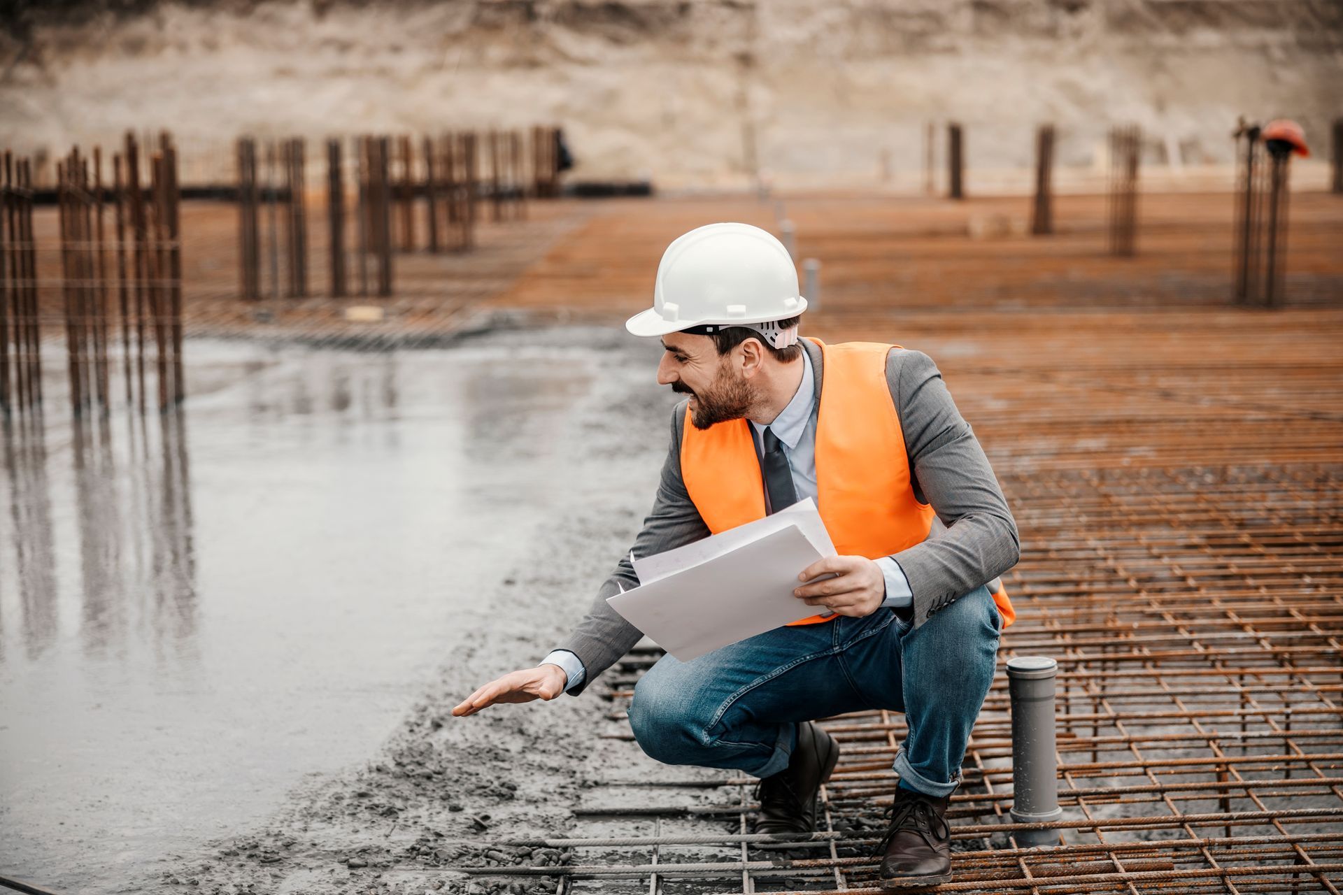 A construction worker is kneeling down on a construction site looking at a blueprint in Boise, Idaho.