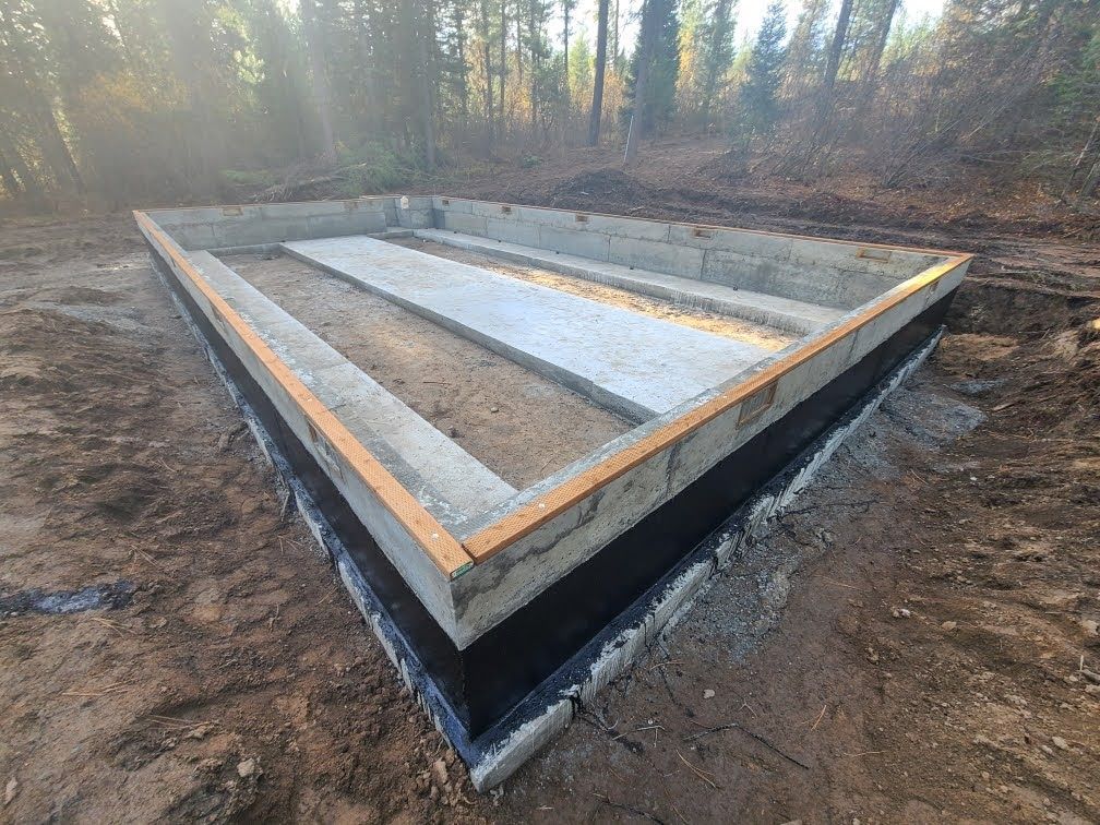A concrete foundation is being built in the middle of a forest.