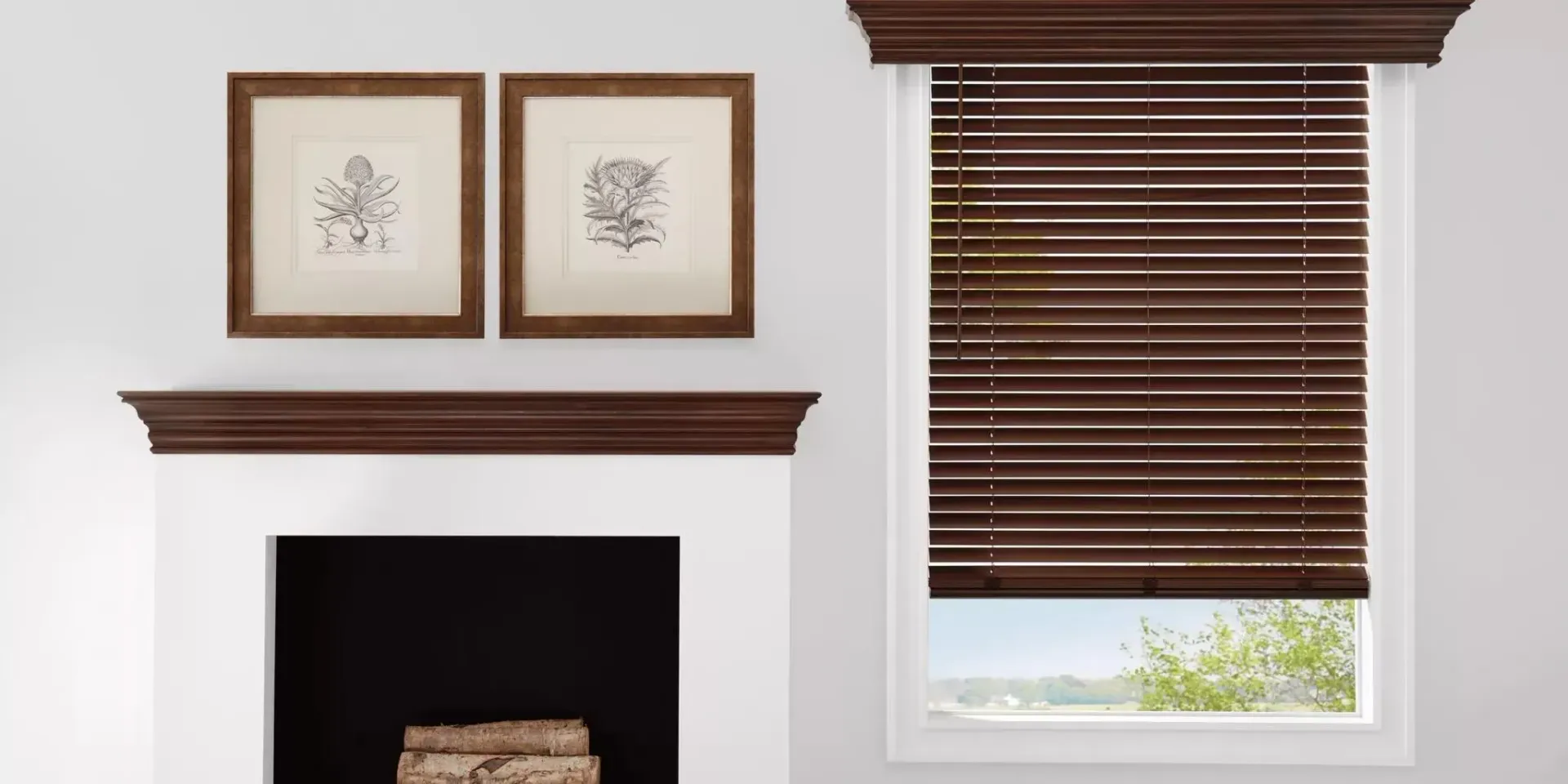Fireplace with dark wood blinds and frames hanging on a white wall.