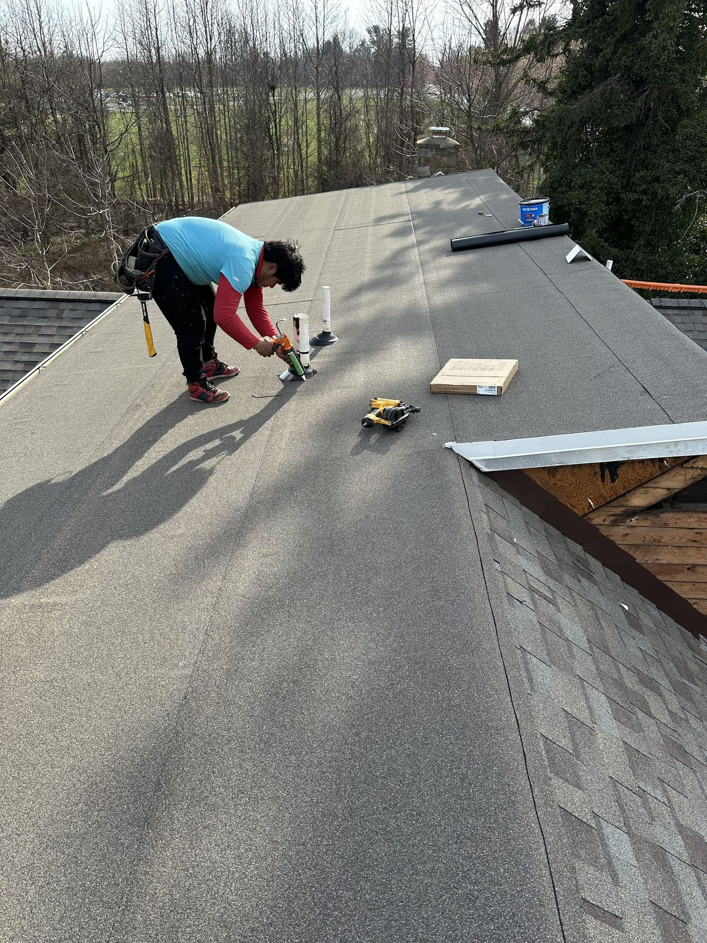 A man is working on the roof of a house.