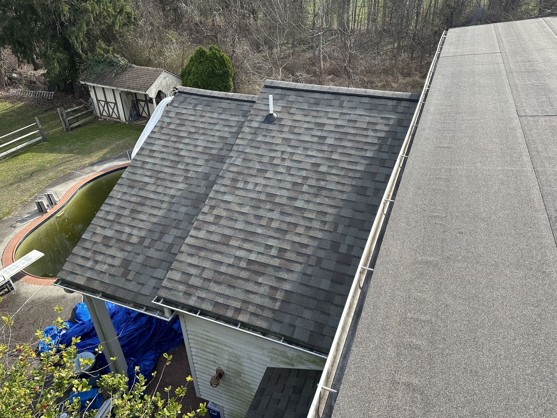 An aerial view of a house with a roof that has shingles on it.