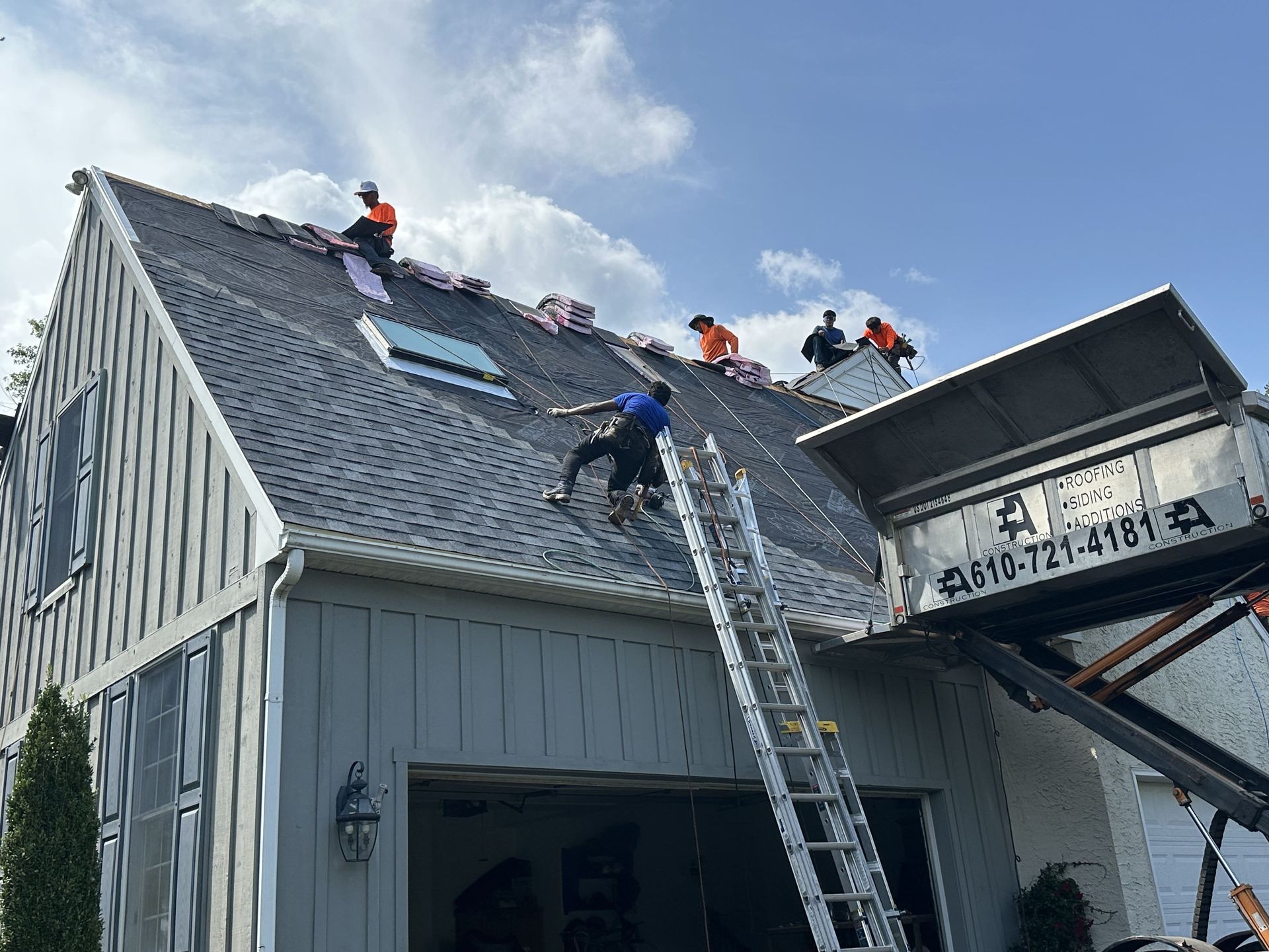 A group of people are working on the roof of a house.
