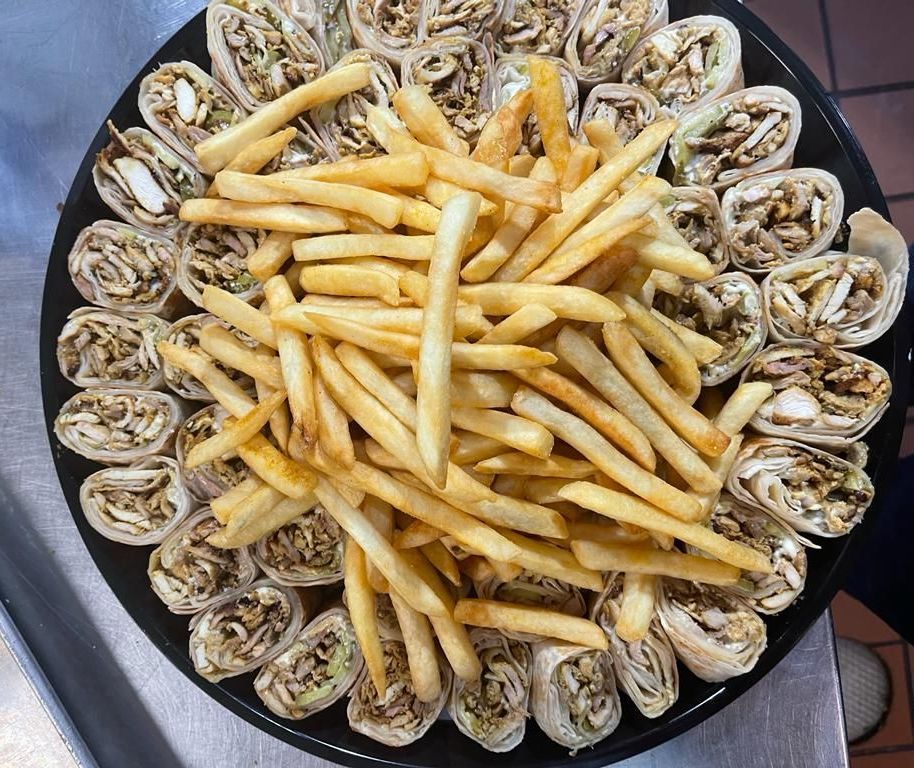 A plate of food with french fries and wraps on it