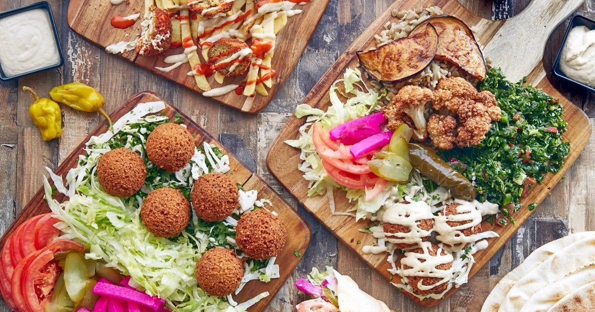 There are many different types of food on the cutting boards on the table.