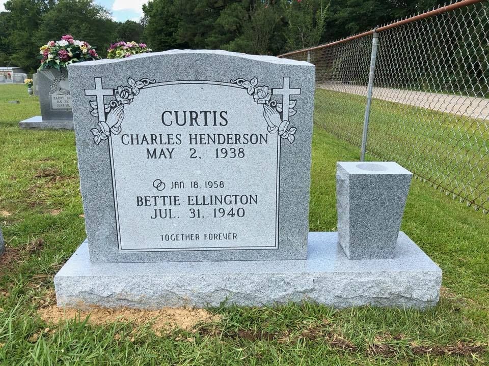 A gravestone for curtis charles henderson is in a cemetery.