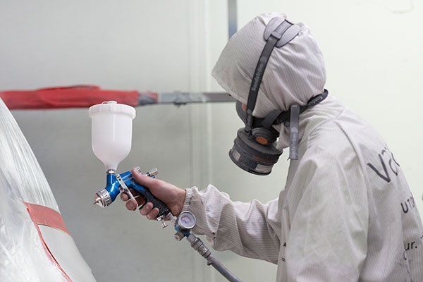 Person in Protective Gear Sprays Paint — Mid City Smash Repairs in Dubbo, NSW