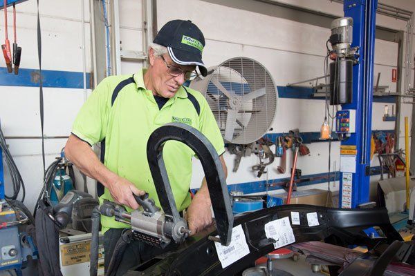 Mechanic in a Green Shirt and Cap — Mid City Smash Repairs in Dubbo, NSW