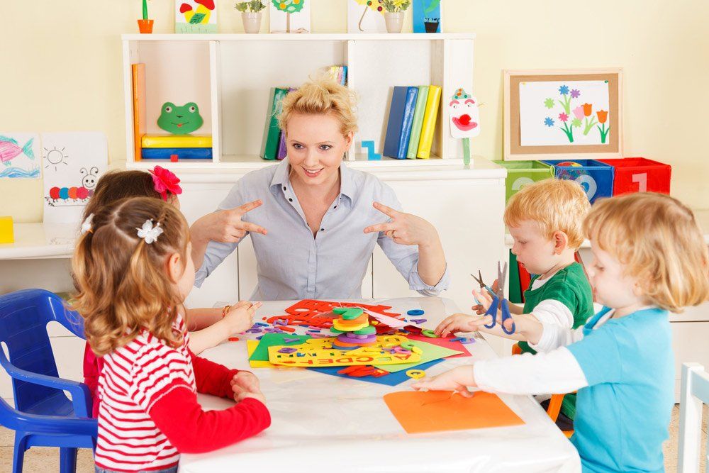 Four Day Care Children In The Classroom With The Teacher — Grandma Rosie’s Quality Long Day Care In Wollongong, NSW