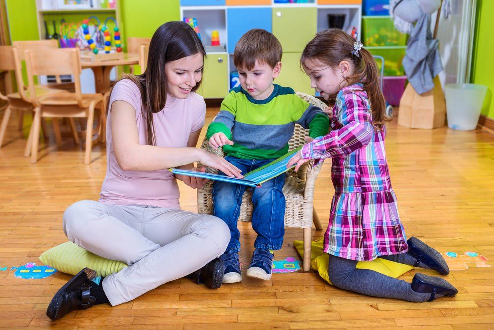 Kids Reading-a Book With-Kindergarten Teacher — Grandma Rosie’s Quality Long Day Care In Wollongong, NSW