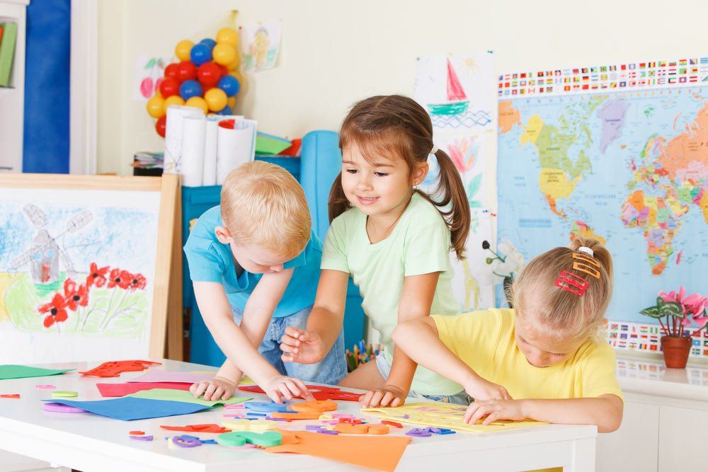 Three Preschoolers In The Classroom Doing Logical Shapes On The Table — Grandma Rosie’s Quality Long Day Care In Wollongong, NSW