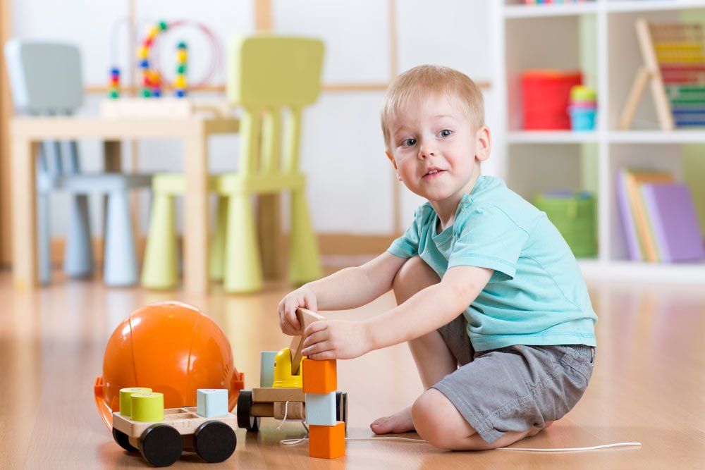 Child Boy Toddler Playing With Toy Car Indoors — Grandma Rosie’s Quality Long Day Care In Wollongong, NSW