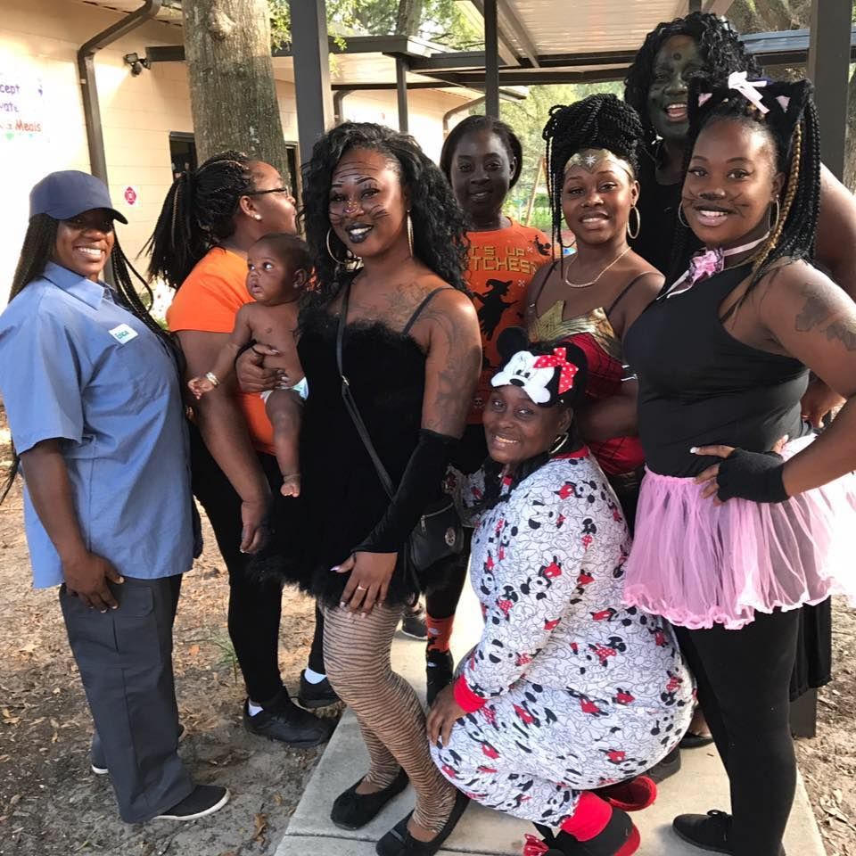 A group of people posing for a picture with one woman holding a baby