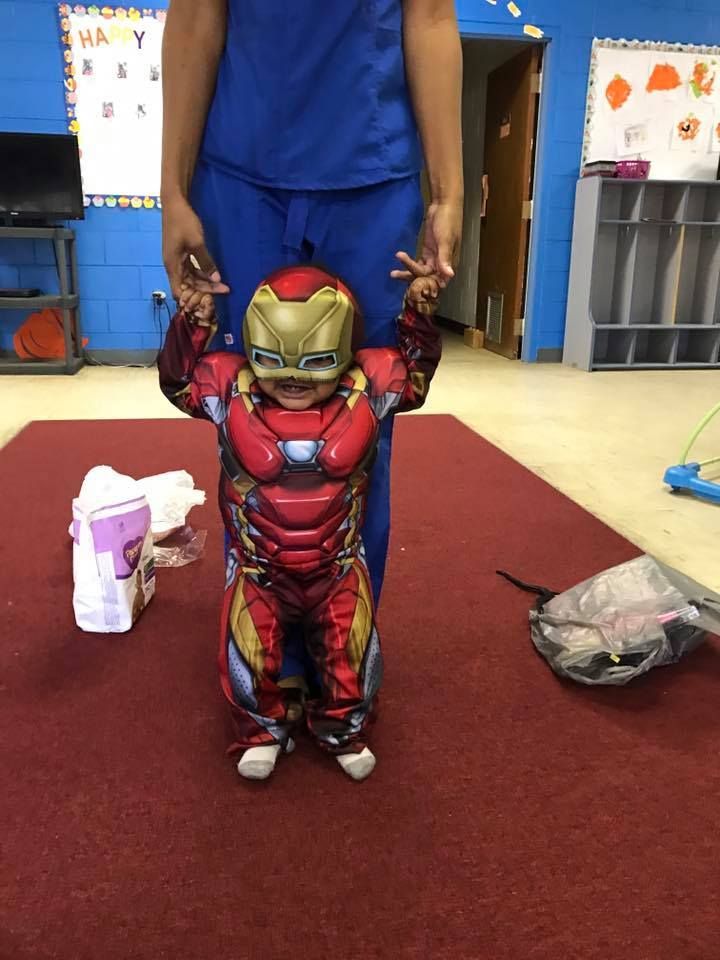 A child in an iron man costume is standing next to a man