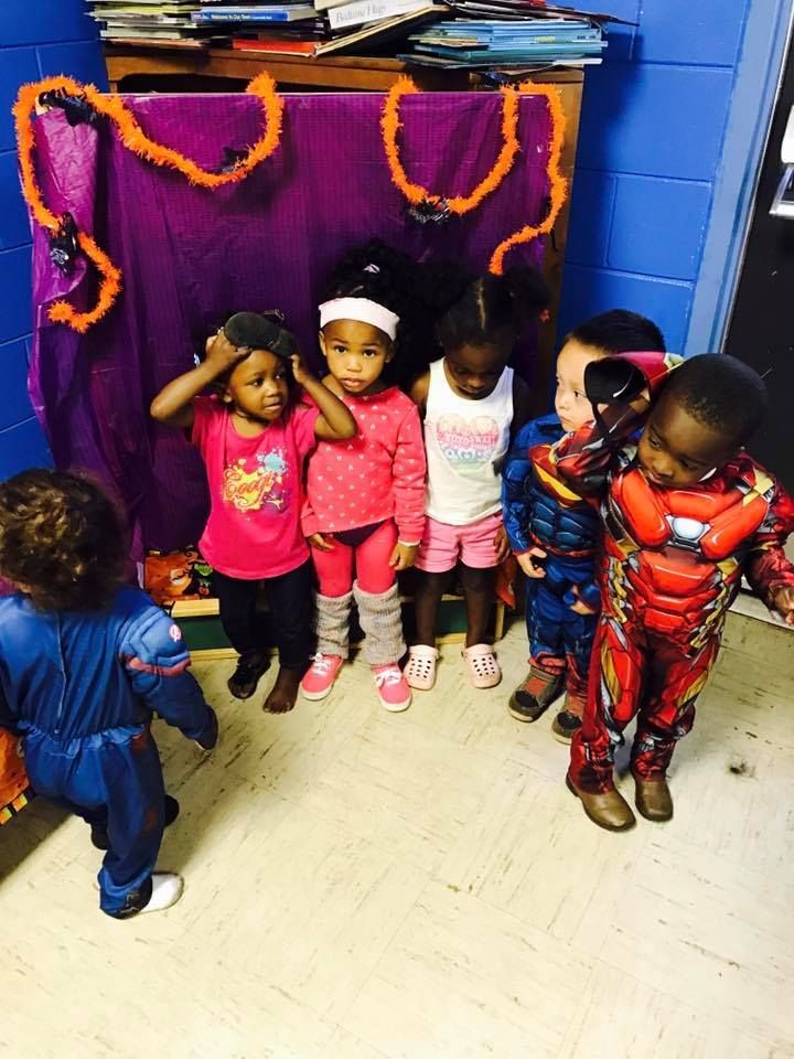 A group of children in costumes are standing in a room