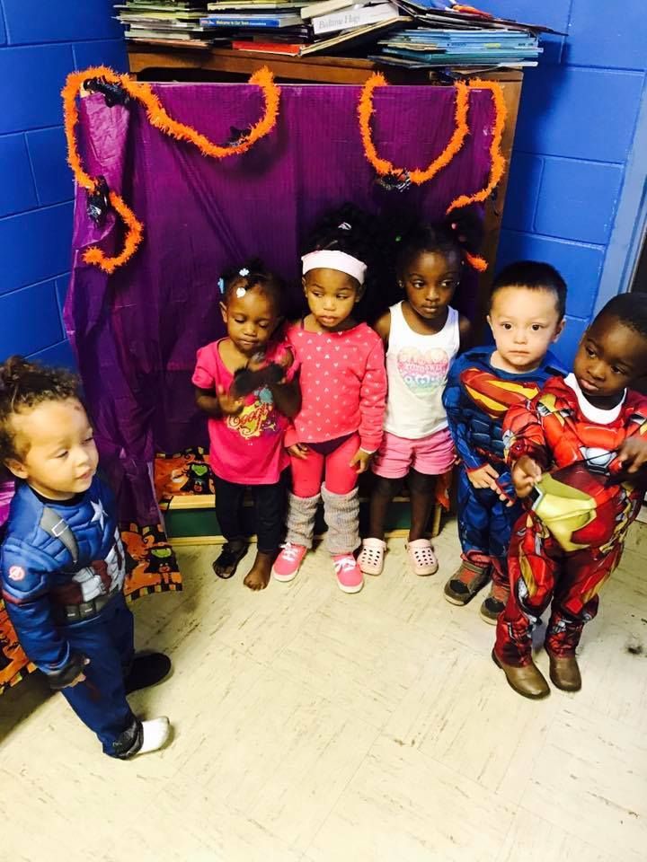 A group of children in costumes are standing in a room