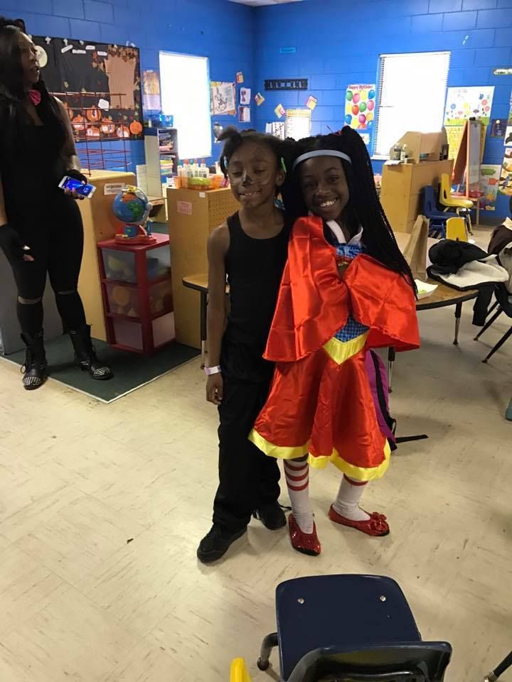 Two children dressed in superhero costumes are posing for a picture