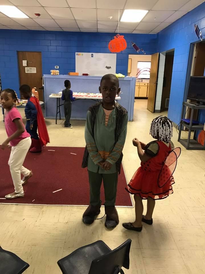 A group of children in costumes are standing in a room.