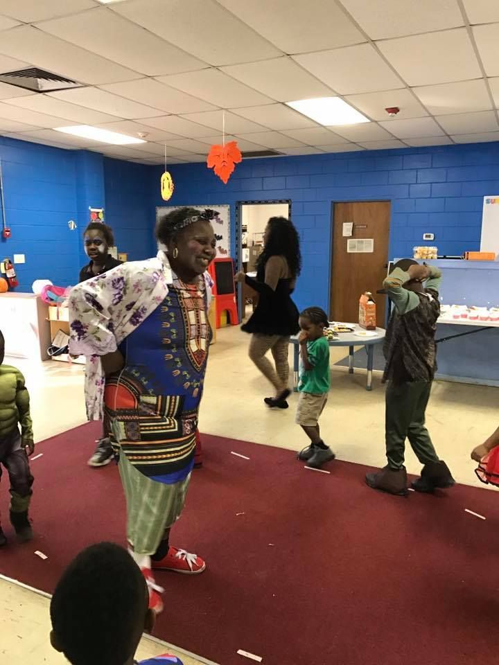 A group of people in costumes are dancing in a room.