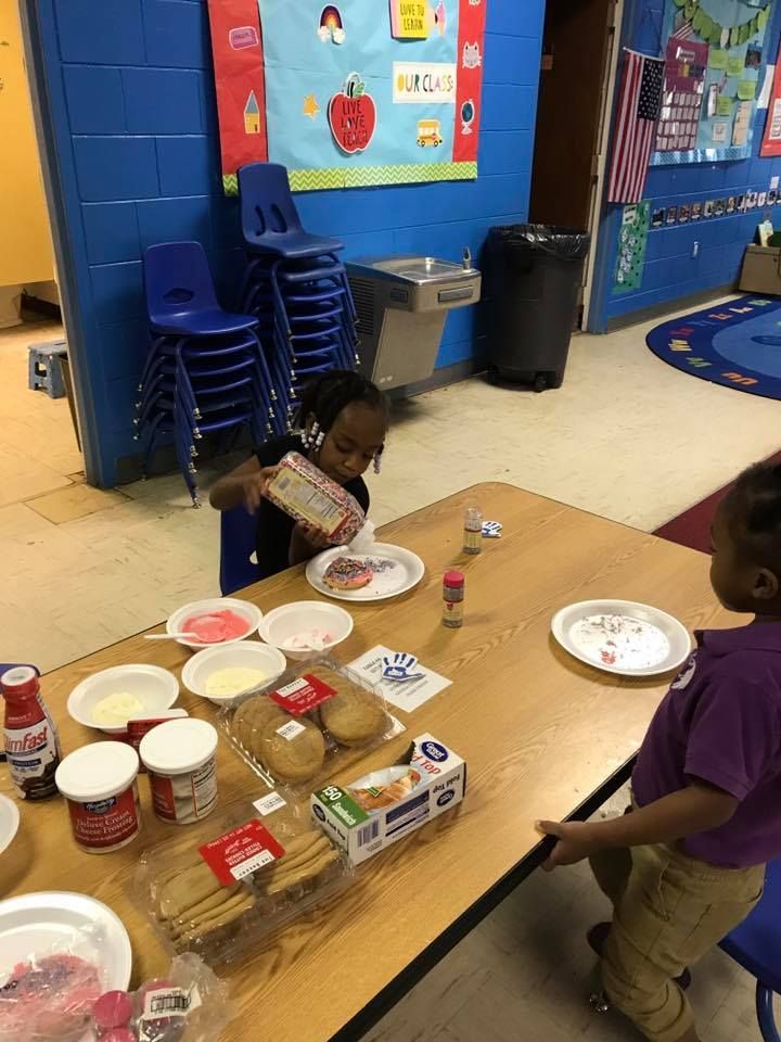 Two children are sitting at a table with plates of food.
