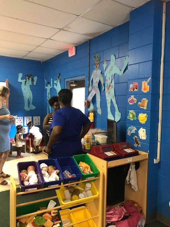 A group of people are standing in a room with blue walls