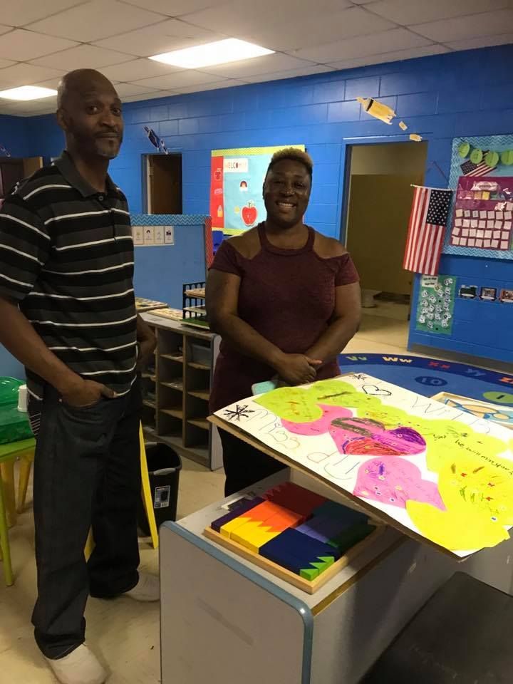 A man and a woman are standing next to each other in a classroom