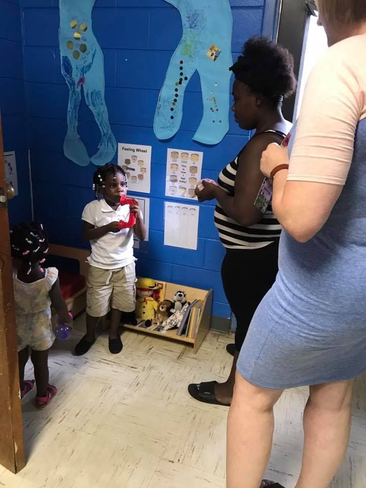 A group of people standing in a room with a blue wall