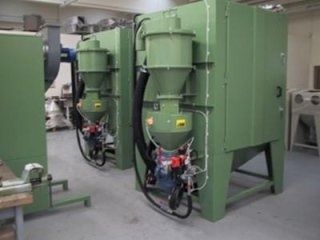 Macchinari industriali verdi in un'officina, con tubi e cavi collegati alle unità anteriori.