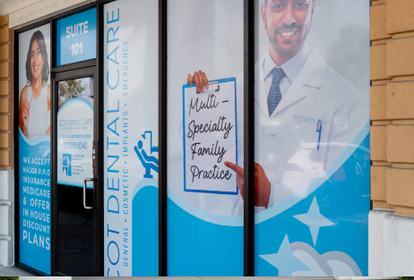 Exterior of a dental office; blue and white signage with two smiling individuals and the words,