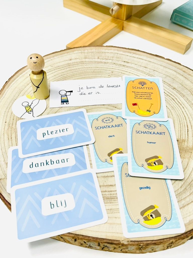 Blauwe en crèmekleurige flashcards op een tafel, met daaronder een klein houten beeldje en een rond, geweven dienblad.