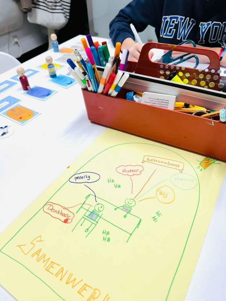 Tekentafel met kleurrijke pennen, stiften en een handgetekende schets op papier.