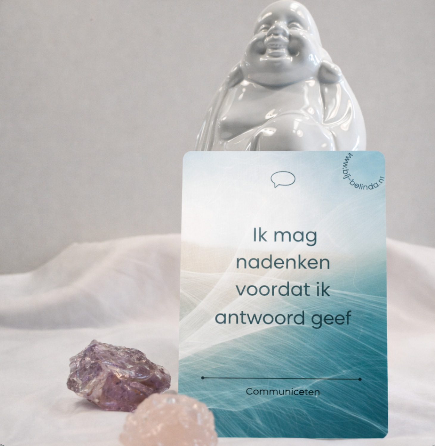 Japanese quote card reading “Ik mag nadenken voordat ik antwoord geef” beside a crystal and Buddha figurine