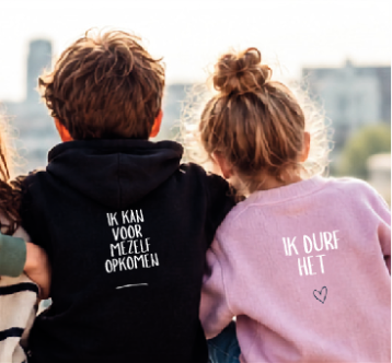 Drie mensen poseren samen tegen een witte achtergrond, lachend en met handgebaren.