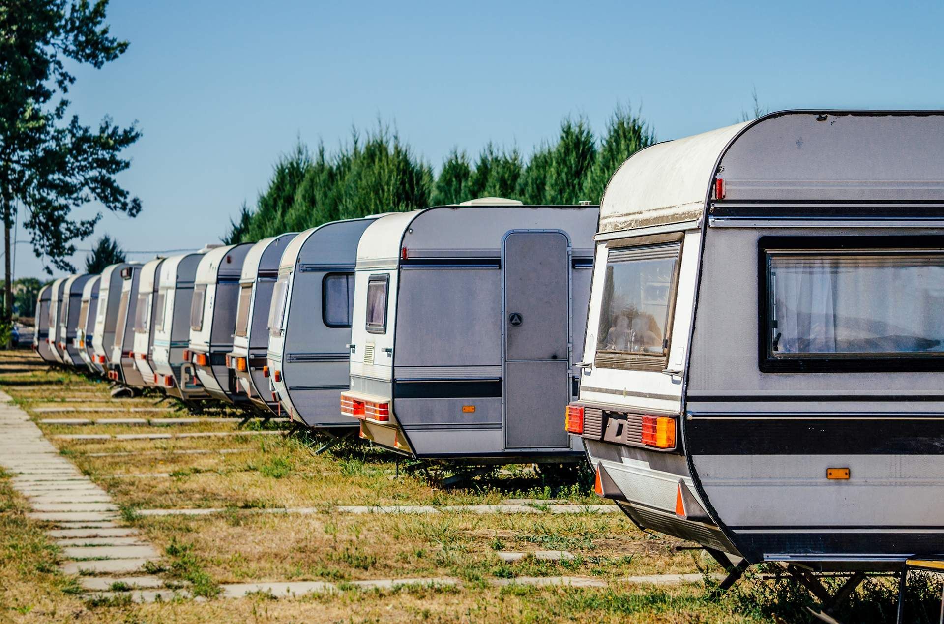 A row of caravans parked next to each other in a field.