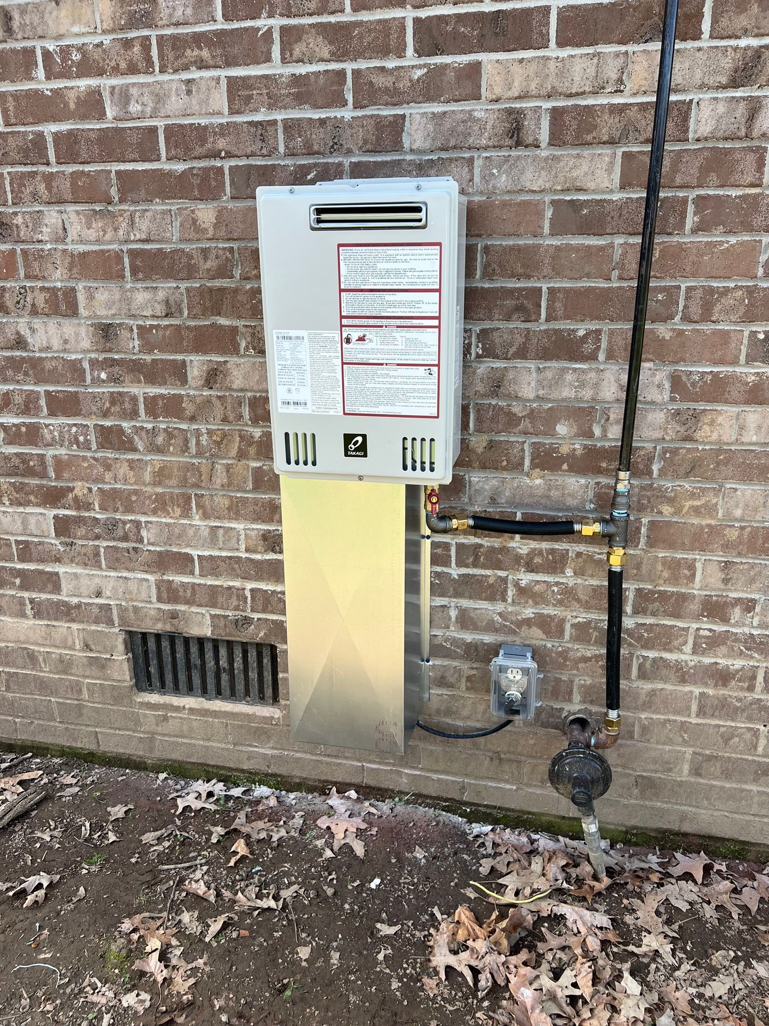 Emergency Services repair and replace white outdoor door A gas water heater is installed on the side of a brick building.